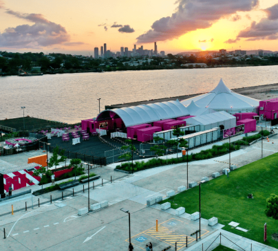 Aerial view of a Pink Flamingo at sunset. The venue features a large white tent and pink structures.