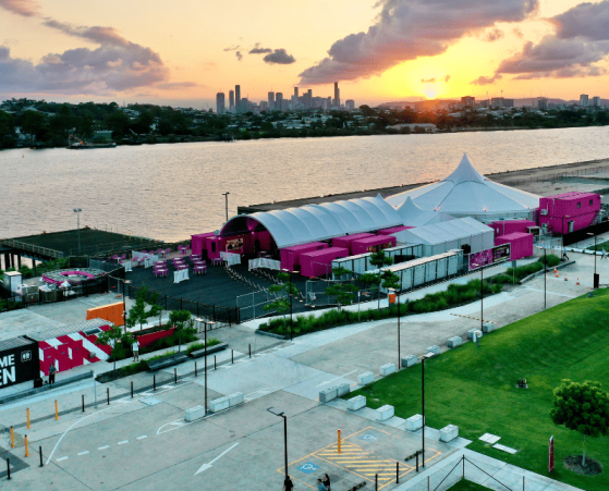 Aerial view of a Pink Flamingo at sunset. The venue features a large white tent and pink structures.