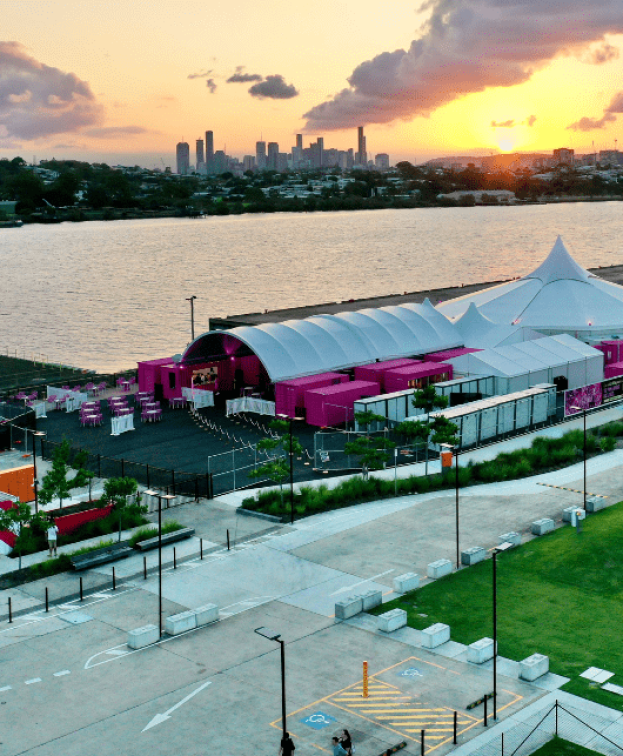 Aerial view of a Pink Flamingo at sunset. The venue features a large white tent and pink structures.