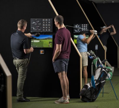 To people look at their golf stats onscreen at the Golf Bunker.
