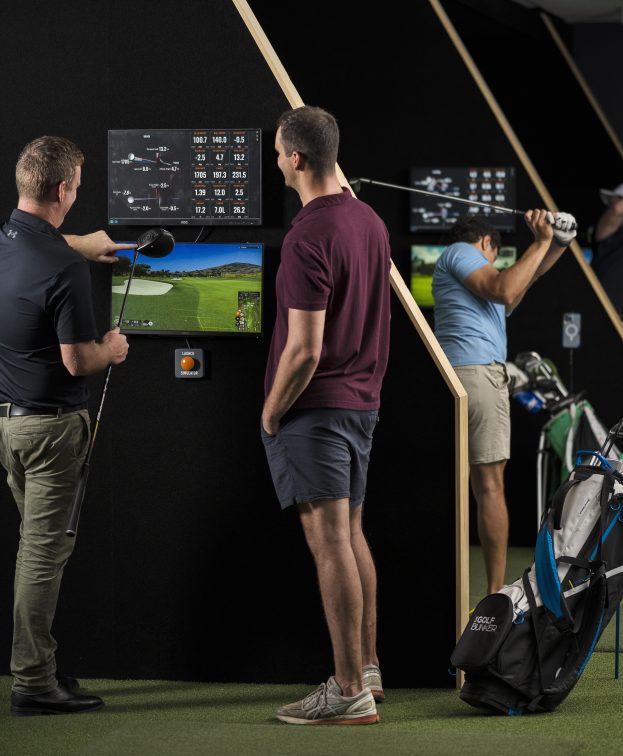 To people look at their golf stats onscreen at the Golf Bunker.